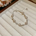 Elegantes Perlenarmband mit Silberakzenten und Glitzersteinen in einer Schmuckschale. - Rosa-Violetter Perlen-Strass-Stil / Silber