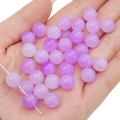 Two-tone purple and pink gradient acrylic jelly beads held in hand for DIY jewelry making - Purple Series