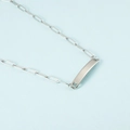Detailed macro view of polished silver rectangle bar pendant on a paperclip chain necklace - Steel
