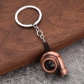 Detailansicht eines Turbo-Schlüsselanhängers aus Bronze auf Holz- und Steinhintergrund - Antik Rot