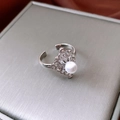 Dettaglio anello fiore in zircone con perla bianca su fascia argento regolabile - Argento
