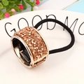 Polsino per coda di cavallo con strass champagne ed elastico nero su piatto bianco - Stile Zirconia / Oro