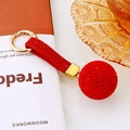 Detail shot of a crystal-studded red sphere keychain with a gold ring and matching strap - Single OPP Bag Packaging / Red