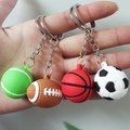 Detalle de cuatro llaveros deportivos: tenis, rugby, baloncesto y balón de fútbol - Estilos Mixtos Aleatorios