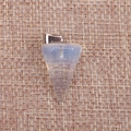 Macro shot of tapered translucent opal stone pendant on textured brown burlap background - Opalite