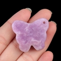 Handheld view of a purple lepidolite crystal butterfly carving with natural textures - Lilac Stone