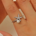 Vue macro de bague étoile de mer argentée avec zircons et perle blanche sur le doigt - Étoile de Mer Perle Artificielle Seule Style B (A-547)
