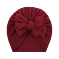Detail of soft burgundy baby beanie showing textured waffle fabric and large bow decoration - Burgundy