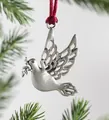 Nahaufnahme einer silbernen Friedenstaube Weihnachtsanhänger mit roten Seidenband Dekor - Friedενstaube