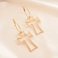 Detail of gold hollowed-out cross earrings displayed on an elegant beige silk fabric background - Small Hoop Style (Gold) / Gold