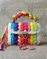 Detailed macro view of rainbow crochet handbag featuring V-pattern and gold metal clasp - Rainbow