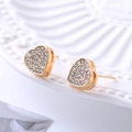 Close-up of heart-shaped gold stud earrings with pavé crystals on a white plate - D18 Gold Heart