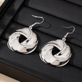 Orecchini a cerchio intrecciati argento lucido con design a spirale su supporto nero - Argento