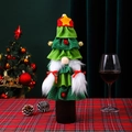 Detail of Christmas tree gnome wine bottle cover with sequin skirt on plaid tablecloth - Female Style (Braid Gnome)