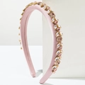 Detailed view of pink satin padded headband with shimmering rhinestones on white display - Pink