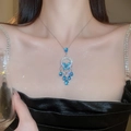 Close-up of elegant silver necklace with blue teardrop zircon and butterfly pendant - Necklace - Silver - Blue