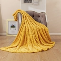 Bright yellow flannel fleece blanket featuring a 3D cable-knit pattern on a soft chair - Turmeric