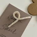 Elegante pinza per capelli in acetato color crema con finitura perlata su un libro - Pinza in Lega a Croce 11CM