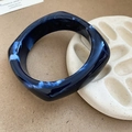 Close-up of dark blue marble texture resin bangle with square round silhouette - Navy Blue with White Marble