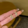 Elegant gold snake earrings with white diamonds featuring a coiled serpent design - Gold