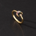 Macro shot of gold crescent moon ring inlaid with colorful rainbow zircons on black background - Rainbow Moon Star Dreamy Style