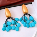 Detail of vintage bohemian teardrop earrings with turquoise stones in a jewelry box - Bohemian Tassel Style / Gold-Blue-Orange