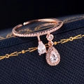 Detalle de anillo en oro rosa con colgantes de gotas de circón sobre estuche de cuero azul - Abierto Ajustable / Oro rosa