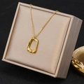 Detail of a golden geometric pendant necklace displayed in a beige jewelry gift box - Irregular Geometric Pendant (26A06011-4) / Gold