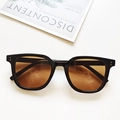 Vista detallada de gafas de sol rectangulares negras con lentes degradadas en ámbar - Montura Negra Lentes de Té