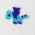 Macro view of blue and purple Miyuki bead dinosaur charm for handmade jewelry - Blue Dinosaur / Blue