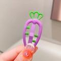 Close-up of cute carrot-shaped candy-colored hair clip in purple and green held by hand - Purple