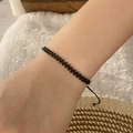 Detailed view of a handwoven black seed bead bracelet worn on a wrist for daily use - Black