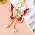 Golden butterfly keychain with red enamel wings, clear rhinestones and faux pearl charms - Red Tassel Butterfly