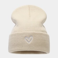 Dettaglio del berretto in acrilico beige con ricamo a cuore argento e trama a maglia - Beige