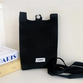 Detail of black knitted phone bag with silver snap button and Stanum logo tag - Black