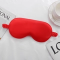 Glossy red faux silk sleep mask with elastic strap on white textured background - Red