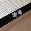 Primo piano di orecchini a lobo con fiori in zircone rosa su carta vintage - Forma di Fiocco di Neve (HE30304) / Rosa