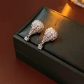 Detailed close-up of hot air balloon earrings with silver metal and zircon inlay - Silver