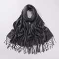 Close-up of dark grey pashmina scarf featuring fringe details and cashmere woven label - Dark Gray