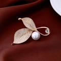 Vista macro detallada del broche de hoja bañado en oro de 18K con perlas y strass brillante - Oro+Blanco (Chapado En Oro De 18K)