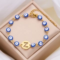 Golden Evil Eye bracelet with blue enamel bead and hollow letter Z pendant on silk background - Letter Z