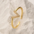 Verstellbarer vergoldeter geometrischer Ring mit Zirkonia-Steinen auf Steinhintergrund - V-Form-Stil / Gold