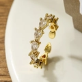 Elegant gold plated open ring with six pear shaped cubic zirconia on a white plate - Adjustable Open / White