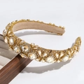 Detailed view of luxury gold headband with champagne crystals and rhinestones on a tray - Yellow