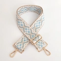 Close-up of ethnic geometric jacquard bag strap with polished gold metal swivel hooks - White Light Blue Floral