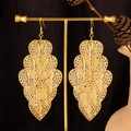 Detailansicht der gestuften goldenen Blattohrringe mit hohlem Herzdesign und Quasten - Hohles Herz / Gold