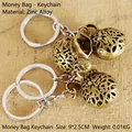 Retro zinc alloy money bag keychain with hollow design and Fu character in brass finish - Multi-size / Money Bag