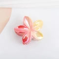 Macro shot of gradient iridescent flower hair claw with glossy finish and pink teeth - Plated Red Yellow