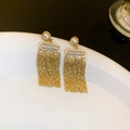 Gros plan sur des boucles d'oreilles à pompon doré avec perles et strass sur céramique - 32# Tige en Argent - Boucles d'Oreilles à Gland de Perle Dorée