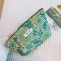 Dettaglio della trousse in jacquard verde a fiori con etichetta in tessuto ricamata - Jacquard Verde Seta Dorata